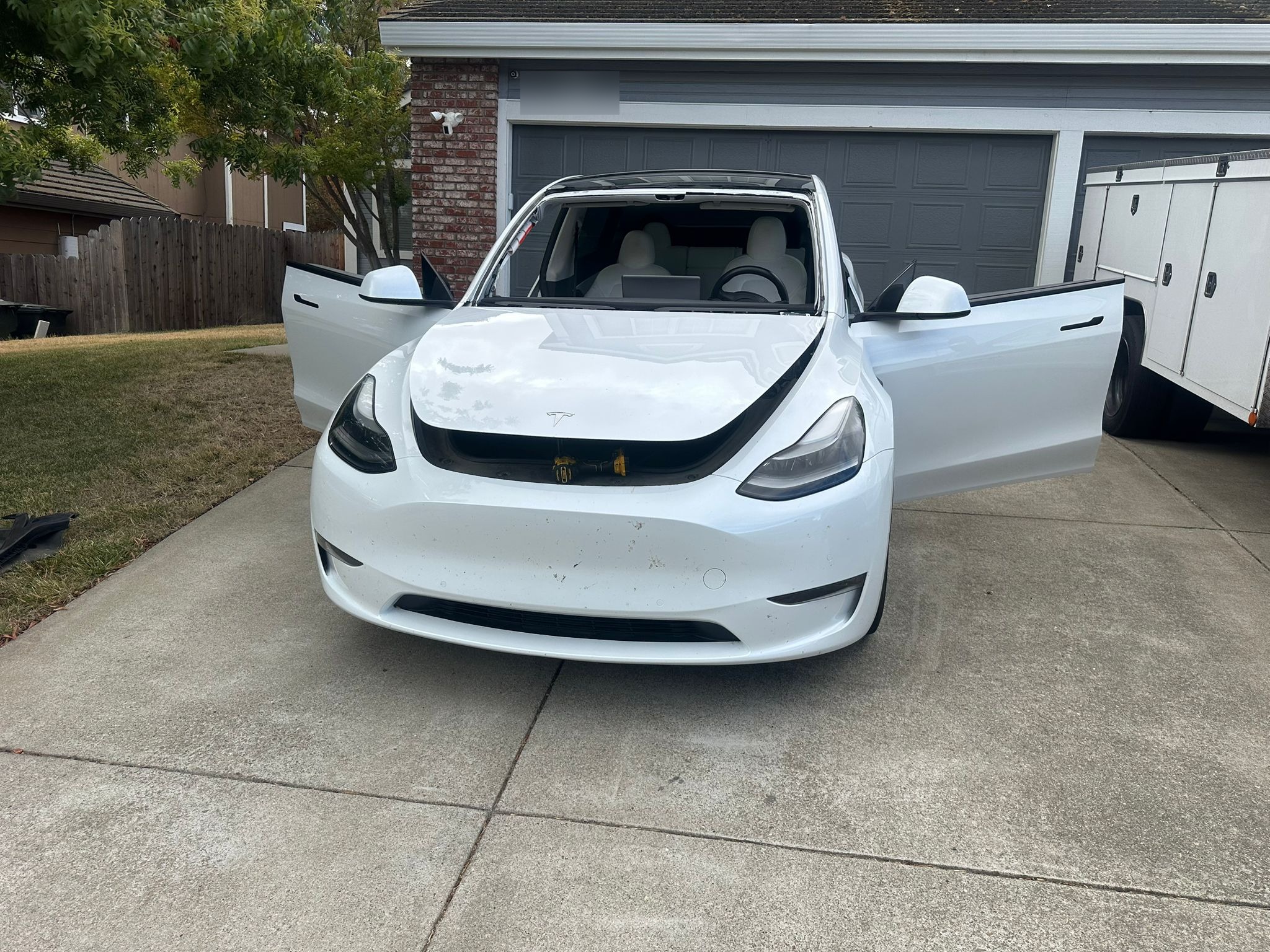 White Tesla Model Y in a Granada Hills driveway during SFV Auto Glass mobile windshield service